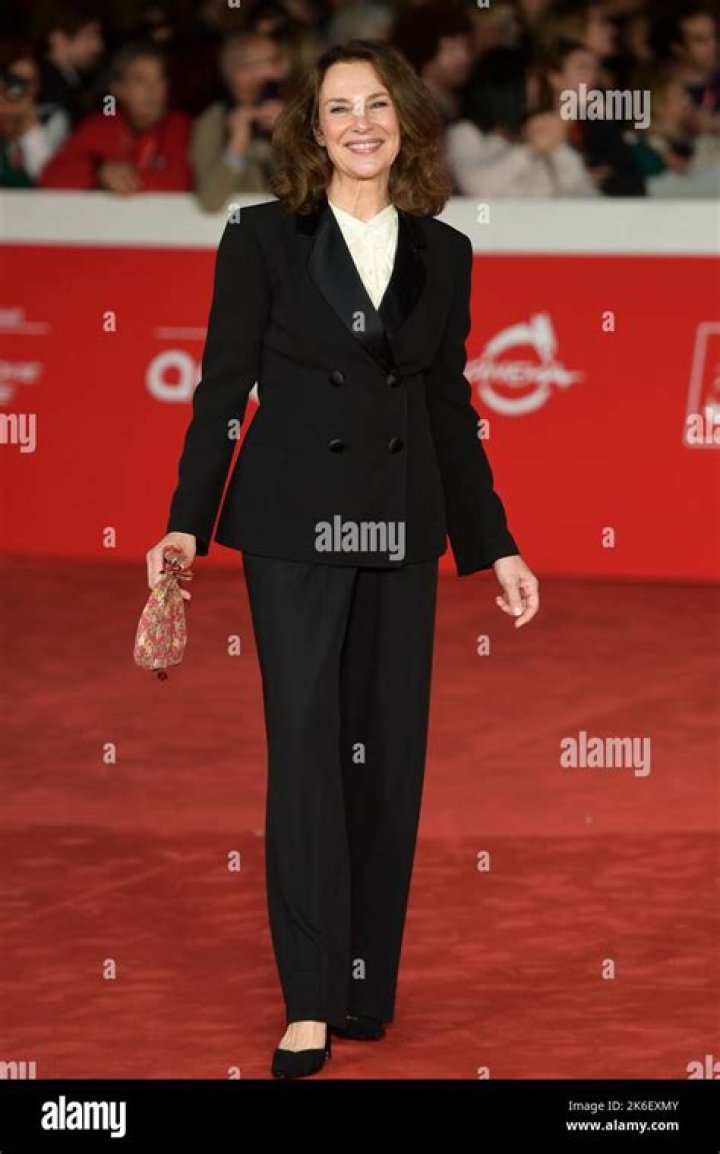 Valeria Cavalli posing for a photoshoot by wearing a white jacket.